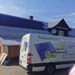 Manufaktura Energii Artur Mrozek - Instalacja paneli słonecznych na dachu domu jednorodzinnego, widoczny firmowy bus z logo i danymi kontaktowymi wykonawcy.