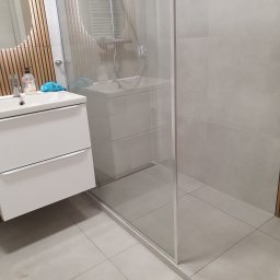 Prysznic liniowy na podwyższeniu.