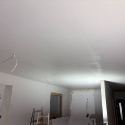 ITS PRO Tomasz Bar - Wnętrze w trakcie odświeżania: pomalowany sufit z widocznymi przewodami, drabina oparta o ścianę przy oknie, ściany częściowo przygotowane do malowania.