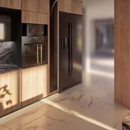 Sebastian Drelichowski - Nowoczesna kuchnia z drewnianymi szafkami, czarnym sprzętem AGD i marmurowym blatem. Na podłodze płytki imitujące marmur. Promienie słońca wpadają przez okno.