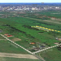 Widok z lotu ptaka na działkę budowlaną z zaznaczonym obrysem, położoną w Wołominie, w otoczeniu zieleni i zabudowy jednorodzinnej, z widocznymi ulicami Radosna i Smugi.