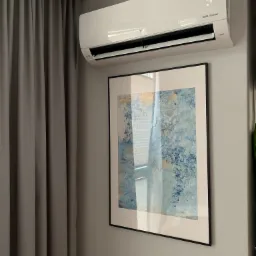 Biały klimatyzator ścienny LG Dual Inverter z wyświetlaczem temperatury 23 stopnie Celsjusza, zamontowany nad obrazem w czarnej ramie na szarej ścianie, obok szarych zasłon.