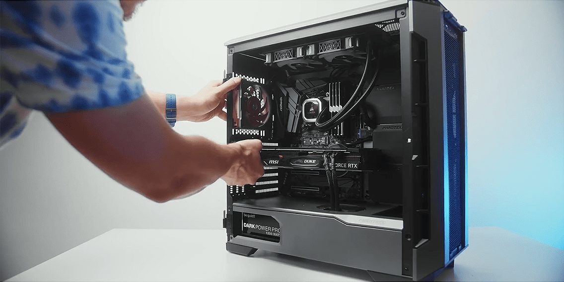 Instalacja karty graficznej MSI Duke GeForce RTX w obudowie komputera Phanteks, widoczny zasilacz be quiet! Dark Power Pro 1200W i chłodzenie wodne Corsair.