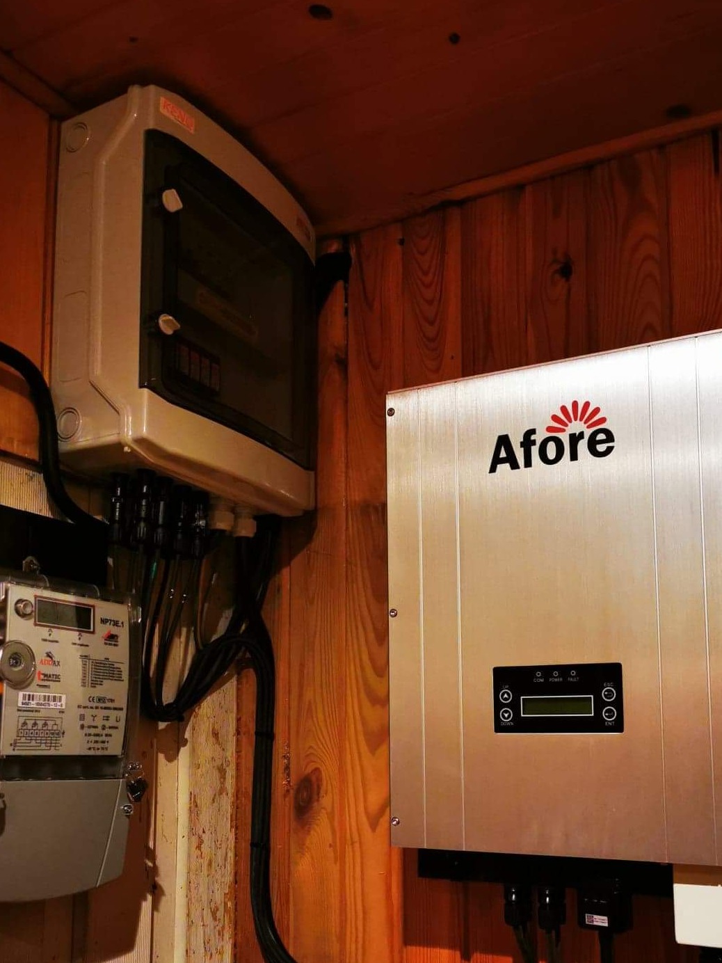 Szczegółowe ujęcie skrzynki elektrycznej, licznika i falownika Afore zamontowanych na drewnianej ścianie, z widocznymi kablami i przewodami.
