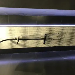 Nowoczesna kabina prysznicowa z czarnymi płytkami, podświetleniem LED i deszczownicą zamontowaną na ścianie pokrytej mozaiką.