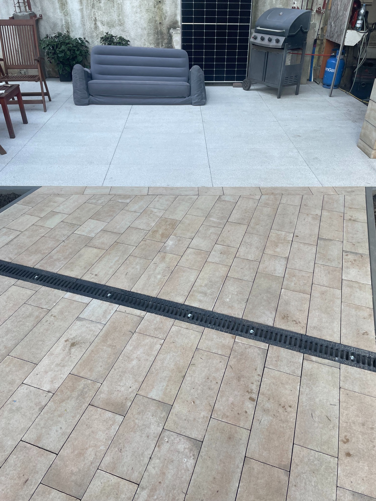 Porównanie nawierzchni: górna część z jasnych płyt, dolna z beżowej kostki brukowej z odpływem liniowym. Widoczne meble ogrodowe i grill.