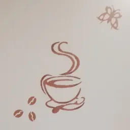 Ręcznie malowany wzór na ścianie przedstawiający filiżankę kawy z parującą kawą, motyla i trzy ziarna kawy w odcieniach brązu na jasnym tle.