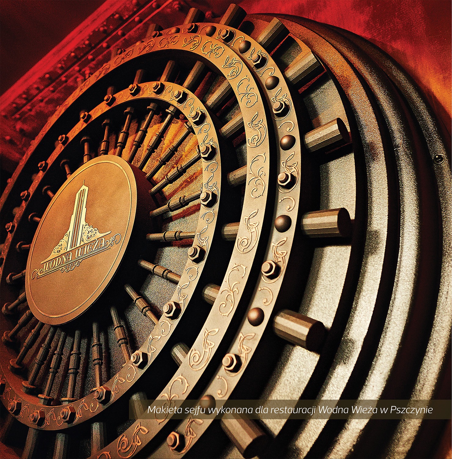 Metalowa makieta drzwi sejfu z dekoracyjnymi elementami i logo restauracji Wodna Wieża, oświetlona czerwonym światłem.