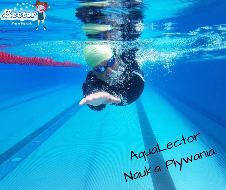 Pływak w czepku i okularkach pod wodą, widoczny z perspektywy podwodnej, z logo szkoły pływania w rogu.