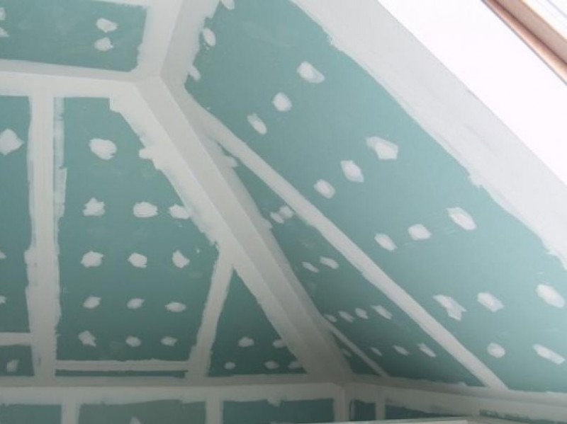 Płyty gipsowo-kartonowe na poddaszu, szpachlowane łączenia, widoczne wkręty, przygotowane do dalszych prac wykończeniowych.