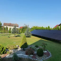 Instalacja paneli fotowoltaicznych Longi Solar na gruncie w Rybniku, widok z góry na rozległy trawnik z ozdobnymi drzewami i krzewami.