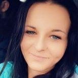 Portret kobiety z ciemnymi włosami i delikatnym makijażem, podkreślającym niebieskie oczy.