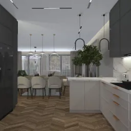 Nowoczesna kuchnia z szarymi szafkami, marmurowym blatem i drewnianą podłogą w jodełkę; w tle widoczna jadalnia z krzesłami obitymi jasną tkaniną.