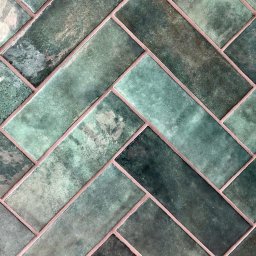 REMMEL Sp. z o.o. - Ułożone w jodełkę, szkliwione, prostokątne płytki w odcieniach zieleni z różową fugą.