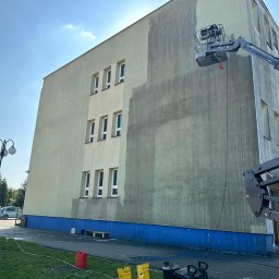 Agnes-Bud Agnieszka Figarska - Częściowo umyta elewacja budynku z podnośnika koszowego. Widoczne różnice w kolorze elewacji przed i po czyszczeniu. Na dole widoczne urządzenia do mycia.