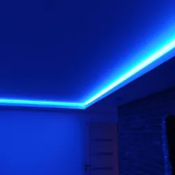 Pokój z niebieskim oświetleniem LED podsufitowym, ściana z cegły w tle, widoczny fragment białych drzwi.