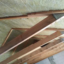 Onsetbud Zhanna Slyvka - Poddasze z drewnianą konstrukcją więźby dachowej wypełnione wełną mineralną, zabezpieczoną sznurkami, widok od dołu.