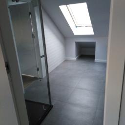 Onsetbud Zhanna Slyvka - Szara łazienka na poddaszu z kabiną prysznicową, oknem dachowym i wnęką w ścianie.