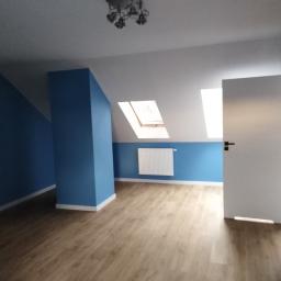 Onsetbud Zhanna Slyvka - Pomalowane na niebiesko poddasze z drewnopodobnymi panelami, białym grzejnikiem pod oknem dachowym i otwartymi białymi drzwiami.