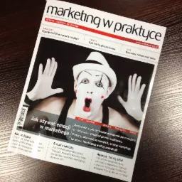 Okładka magazynu 'Marketing w Praktyce' z ilustracją mimu z otwartymi ustami i białymi rękawiczkami, na ciemnym drewnianym tle.
