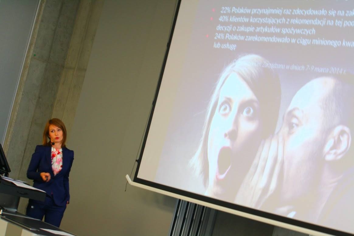 Prezentacja z danymi statystycznymi dotyczącymi rekomendacji konsumenckich, wyświetlana obok prelegentki w niebieskim garniturze.