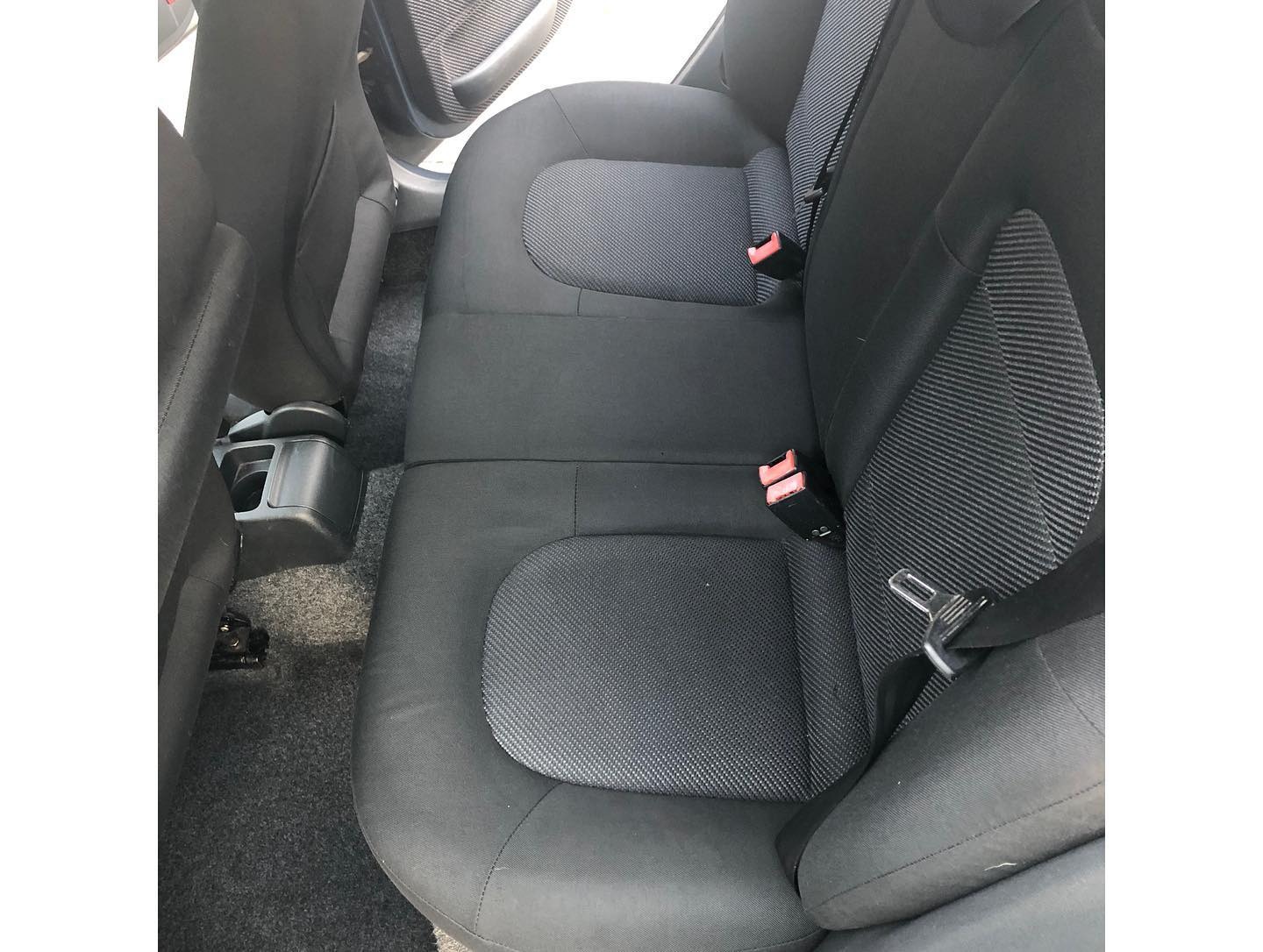 Wnętrze samochodu po czyszczeniu tapicerki w Chorzowie: widok na tylną kanapę z wyraźnie odświeżonymi siedzeniami i pasami bezpieczeństwa.