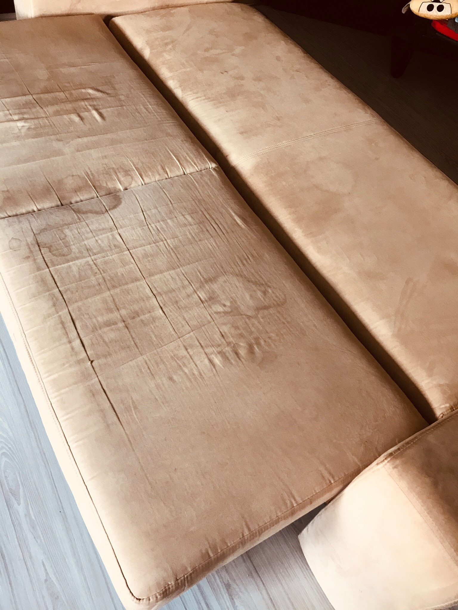 Beżowa kanapa z widocznymi plamami na siedzisku, ukazująca potrzebę odświeżenia tapicerki.