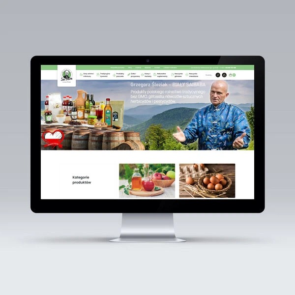 Monitor wyświetlający stronę internetową z produktami rolnictwa tradycyjnego i portretem Grzegorza Śleziaka, z widocznymi kategoriami produktów i elementami graficznymi.