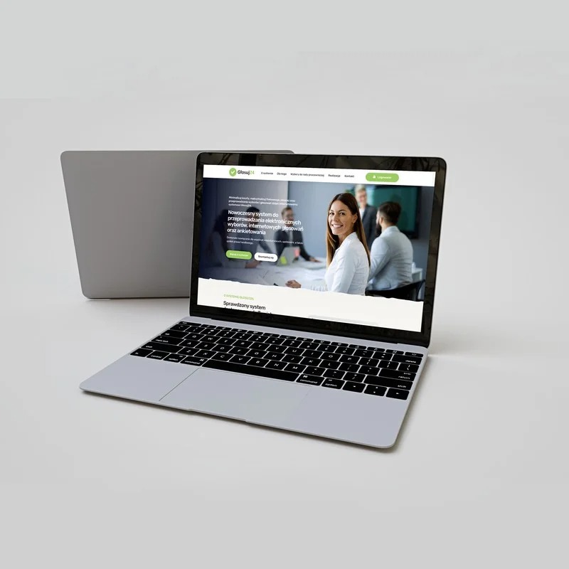 Dwa laptopy na białym tle, na ekranie otwartego laptopa widoczna strona internetowa z uśmiechniętą kobietą i tekstem dotyczącym systemu do przeprowadzania elektronicznych wyborów i ankiet, drugi...