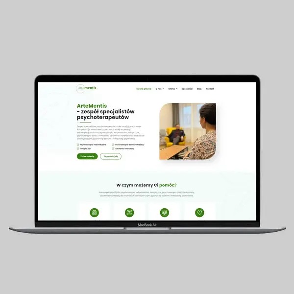 Ekran laptopa MacBook Air prezentujący stronę internetową ArteMentis, zespołu specjalistów psychoterapeutów, z zielono-białym designem i minimalistycznym układem, widoczny fragment strony głównej...
