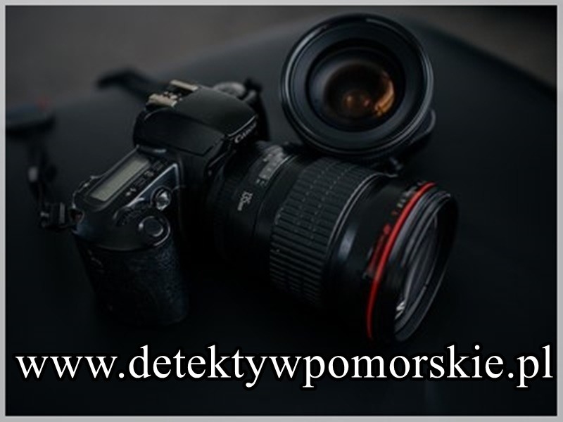 Profesjonalny aparat fotograficzny Canon z obiektywem leżący na ciemnym tle, z widocznym adresem strony internetowej detektywistycznej.