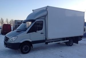 Biały samochód dostawczy Mercedes-Benz Sprinter z zabudową kontenerową, zaparkowany na śniegu w zimowy dzień. Widoczny czarny daszek nad szybą kierowcy.