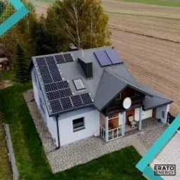 Widok z g&oacute;ry na dom jednorodzinny w Szczawnicy z zainstalowanymi panelami słonecznymi na dachu; część paneli ma inny odcień niż pozostałe.