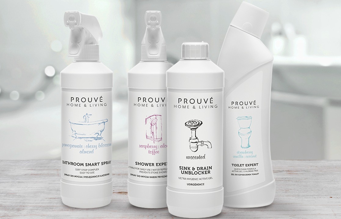 Cztery białe butelki z różnymi środkami do czyszczenia marki Prouvé, z grafikami i nazwami zapachów: do łazienki, kabiny prysznicowej, udrażniacz do zlewów i toalet. Widoczne różne rodzaje opakowań.
