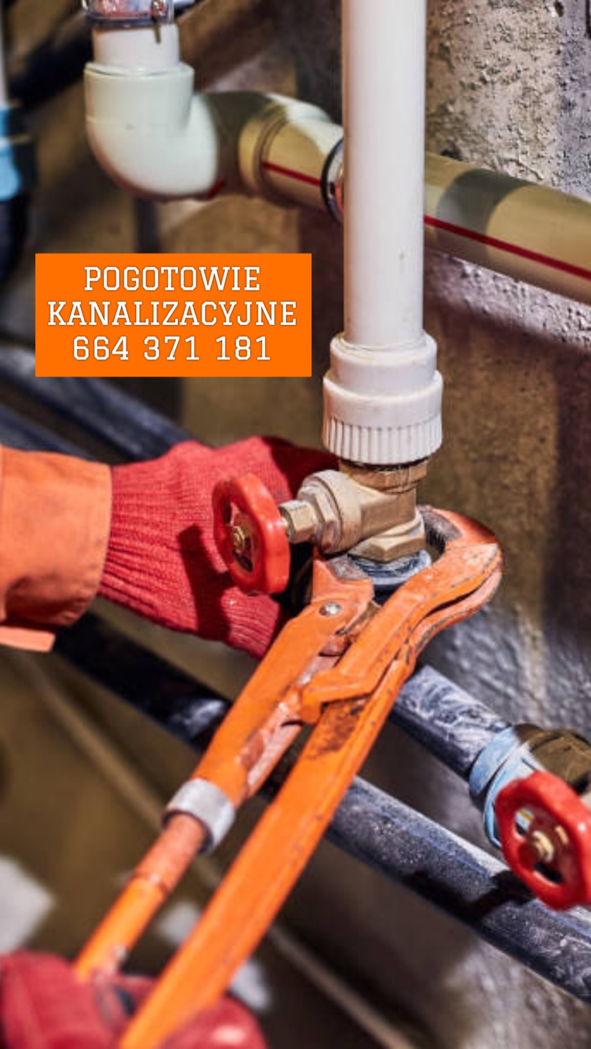 Pomarańczowe rękawice i klucz nastawny chwytają mosiężny zawór na rurze, widoczne inne rury i zawory w tle