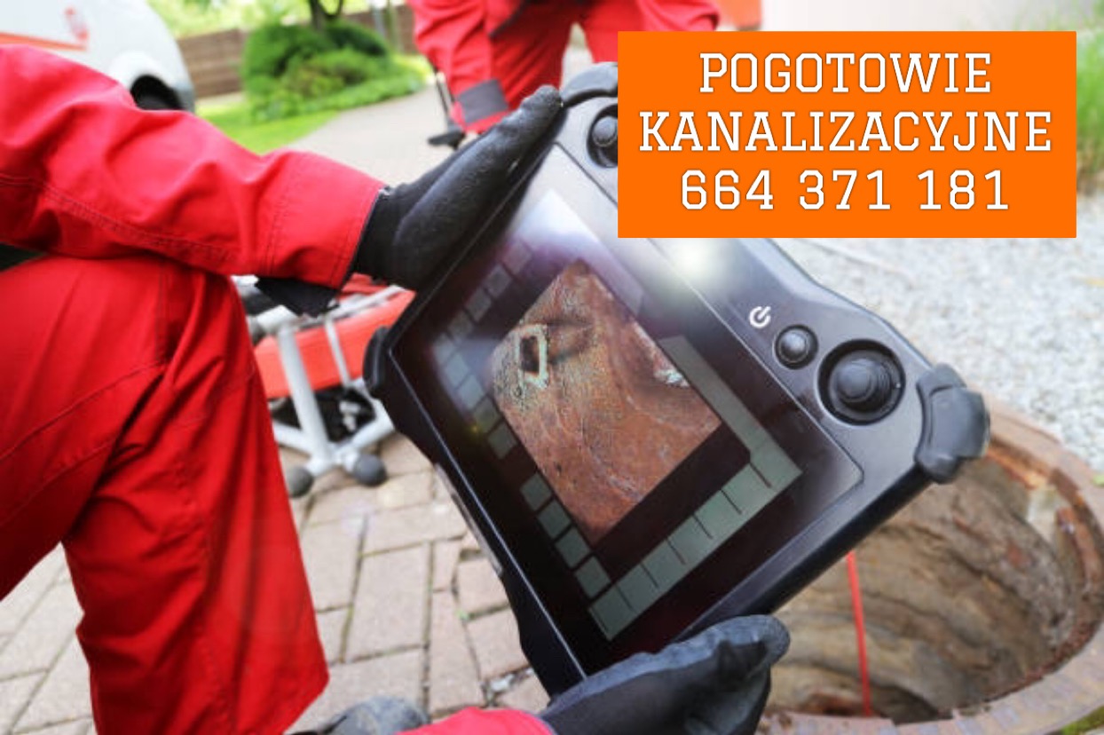Ekran urządzenia diagnostycznego prezentuje obraz z wnętrza rury kanalizacyjnej, widoczny właz studzienki kanalizacyjnej, pracownik w czerwonym kombinezonie w tle.