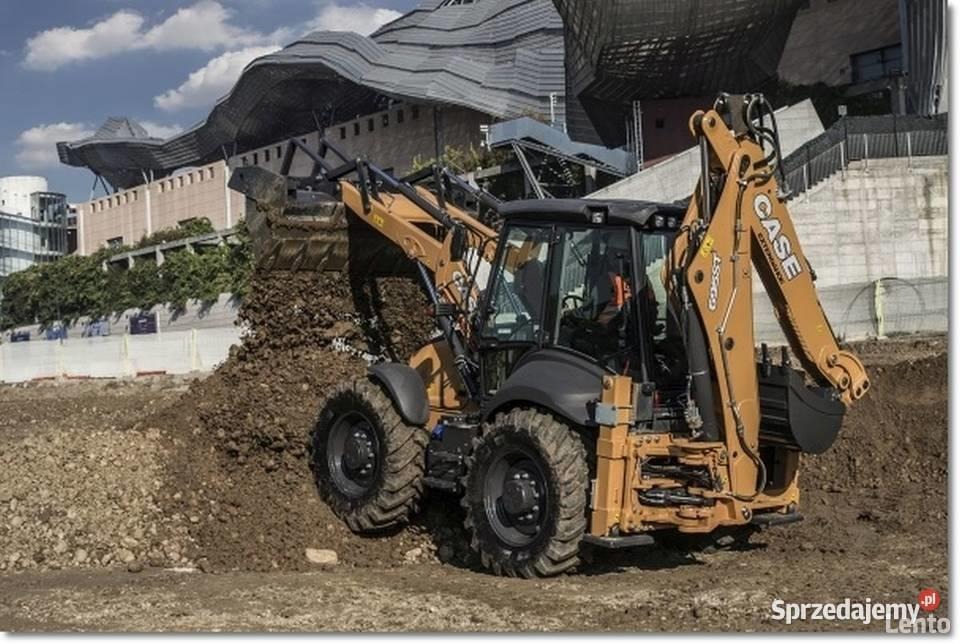 Żółto-czarna koparko-ładowarka CASE podczas prac ziemnych, wysypująca ziemię z łyżki na hałdę, w tle budynek o futurystycznej architekturze.