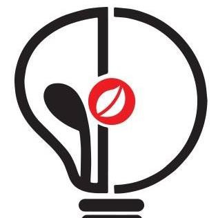 Stylizowana żarówka z elementami graficznymi: po lewej czarny kształt przypominający kroplę, po prawej pusta przestrzeń, w centrum czerwone kółko z białym liściem. Całość na białym tle.