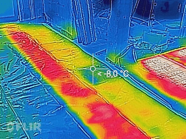 Termowizyjne zdjęcie ogrzewania podłogowego w trakcie instalacji, widoczne rury pod folią, z zaznaczoną temperaturą -8 stopni Celsjusza.