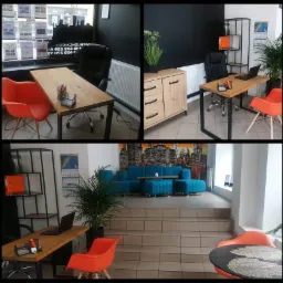 Wnętrze biura agencji nieruchomości: biurka z laptopami, pomarańczowe krzesła, niebieska sofa z widokiem na panoramę miasta na ścianie.