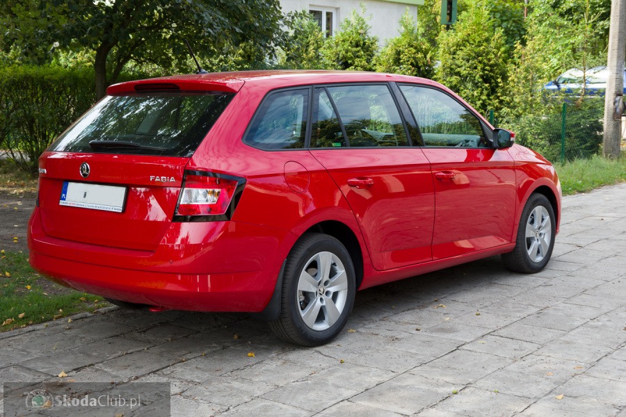 Czerwona Skoda Fabia Combi zaparkowana na chodniku z kostki, widok z tyłu, tablica rejestracyjna zamazana.