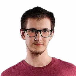 Portret młodego mężczyzny w okularach, ubrany w bordową koszulkę, na białym tle.