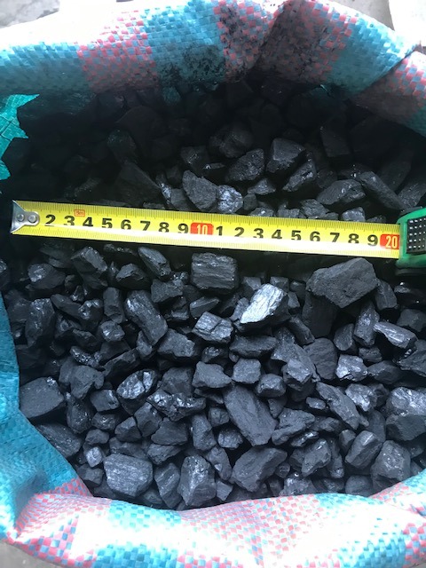 Worek wypełniony bryłami węgla, z widoczną miarką zwiniętą na wierzchu, wskazującą na rozmiar frakcji.