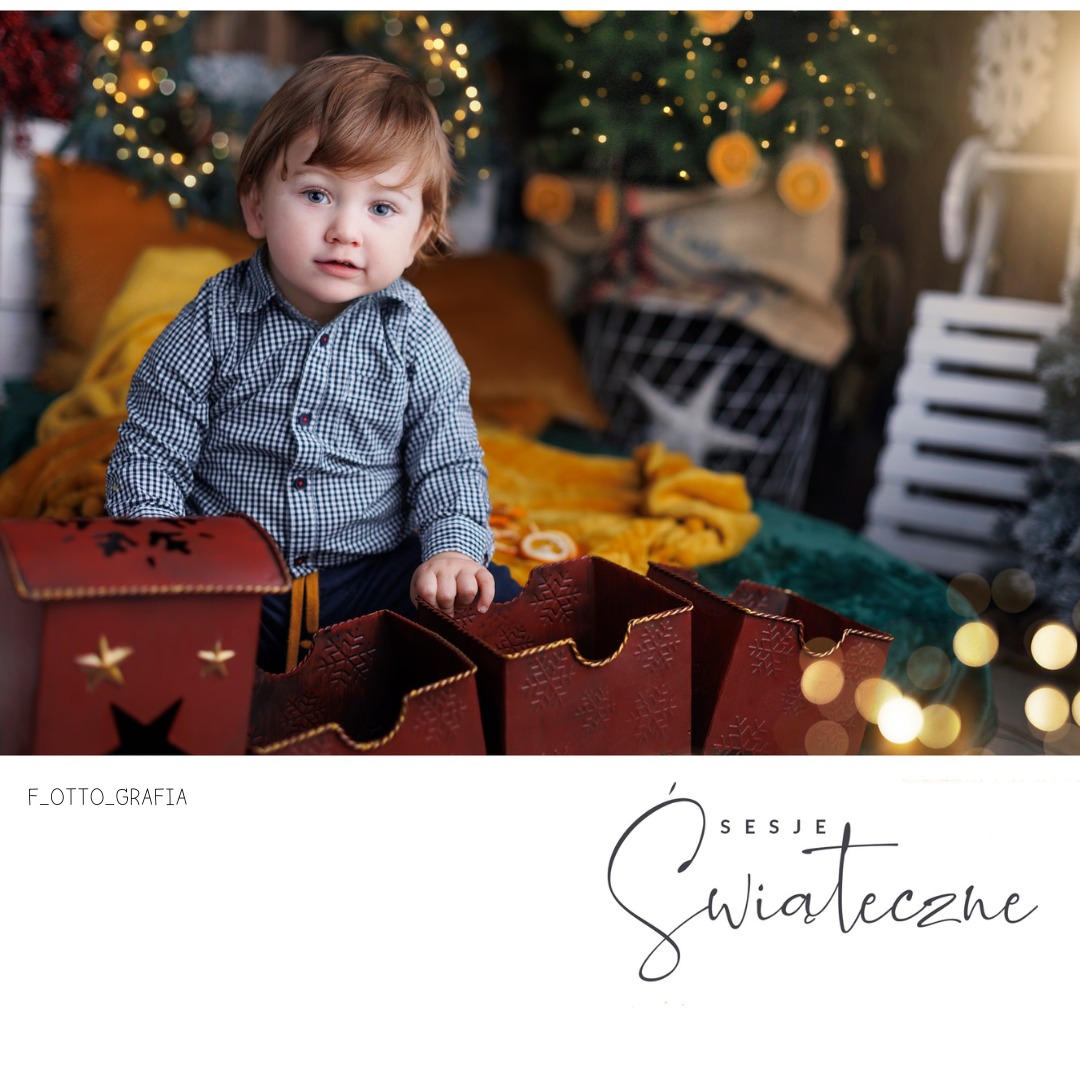 Uroczy chłopiec w świątecznej scenerii, siedzący za dekoracyjnymi pudełkami na tle choinki i ciepłych światełek, tworzący magiczną atmosferę sesji zdjęciowej.