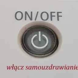 Przycisk ON/OFF z symbolem zasilania na białym tle, z dopiskiem 'włącz samouzdrawianie'.