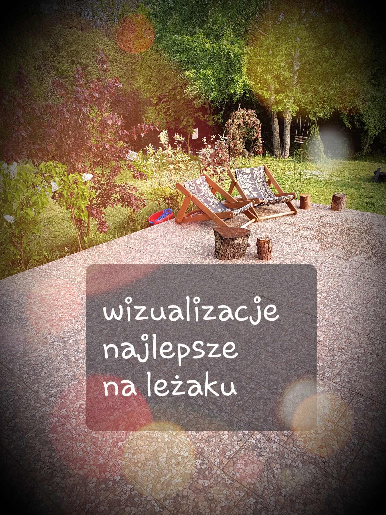 Dwa puste leżaki ogrodowe na tarasie z widokiem na zieleń, obok pniaki służące jako stoliki. Na pierwszym planie napis 'wizualizacje najlepsze na leżaku'.