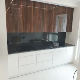 kuchnia w jednej linii, fronty górne na wysoki połysk, na dole pochwyty biały lakier