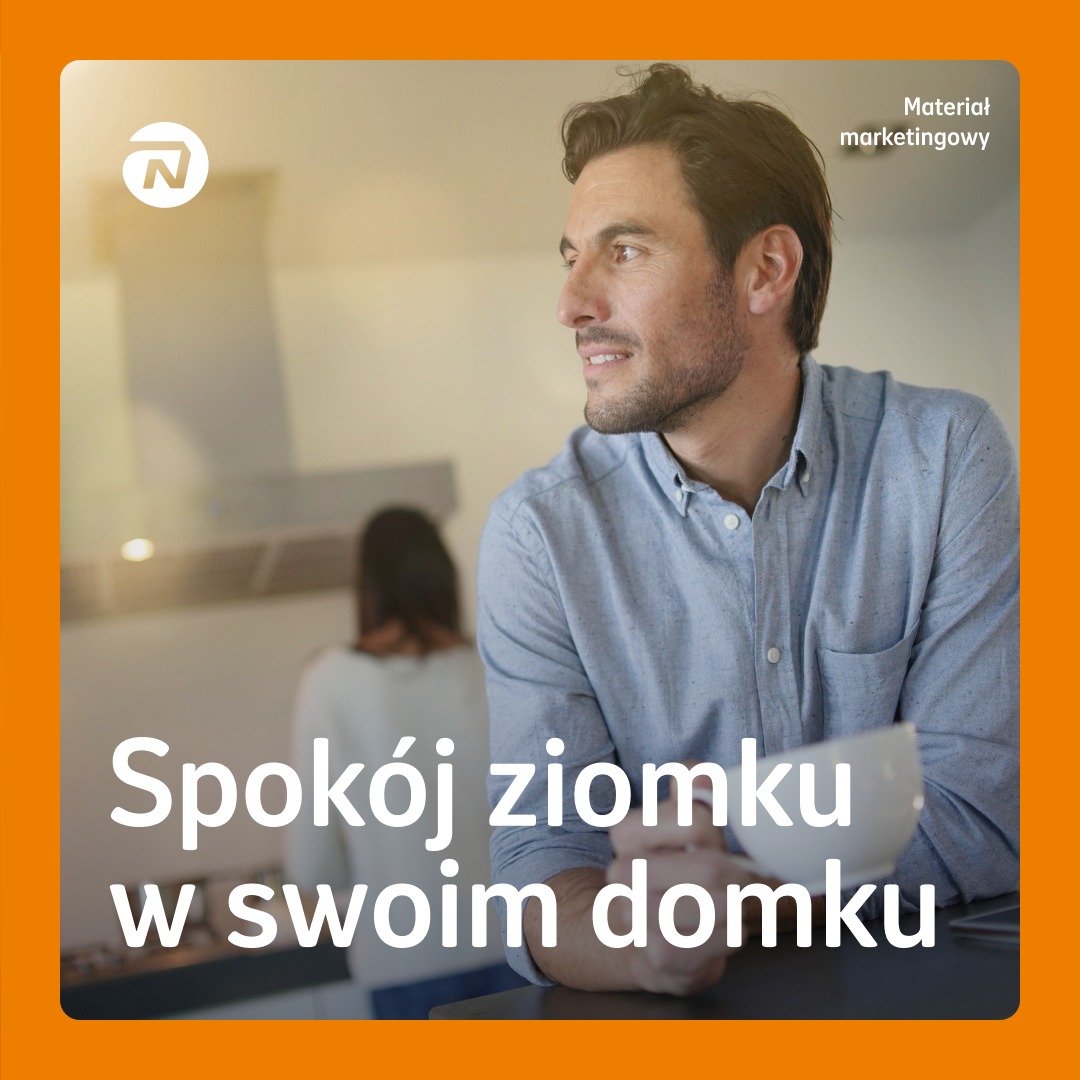 Uśmiechnięty mężczyzna w jasnej koszuli patrzy w dal w nowoczesnym wnętrzu domu, z widoczną kobietą w tle i napisem 'Spokój ziomku w swoim domku'.