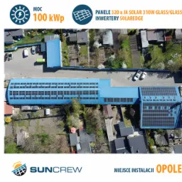 Widok z lotu ptaka na duży, niebieski budynek z zainstalowanymi panelami słonecznymi JA Solar 310W Glass/Glass, moc instalacji 100kWp; logo firmy Suncrew w lewym dolnym rogu, Opole.