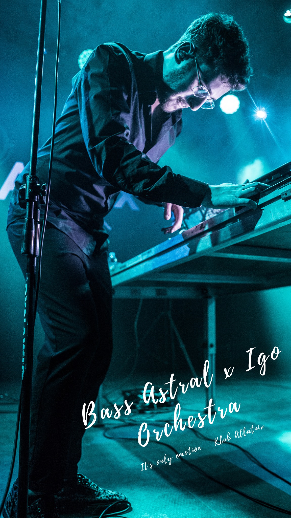Muzyk w okularach gra na keyboardzie podświetlonym na niebiesko podczas koncertu Bass Astral x Igo w Klubie Alaturka.